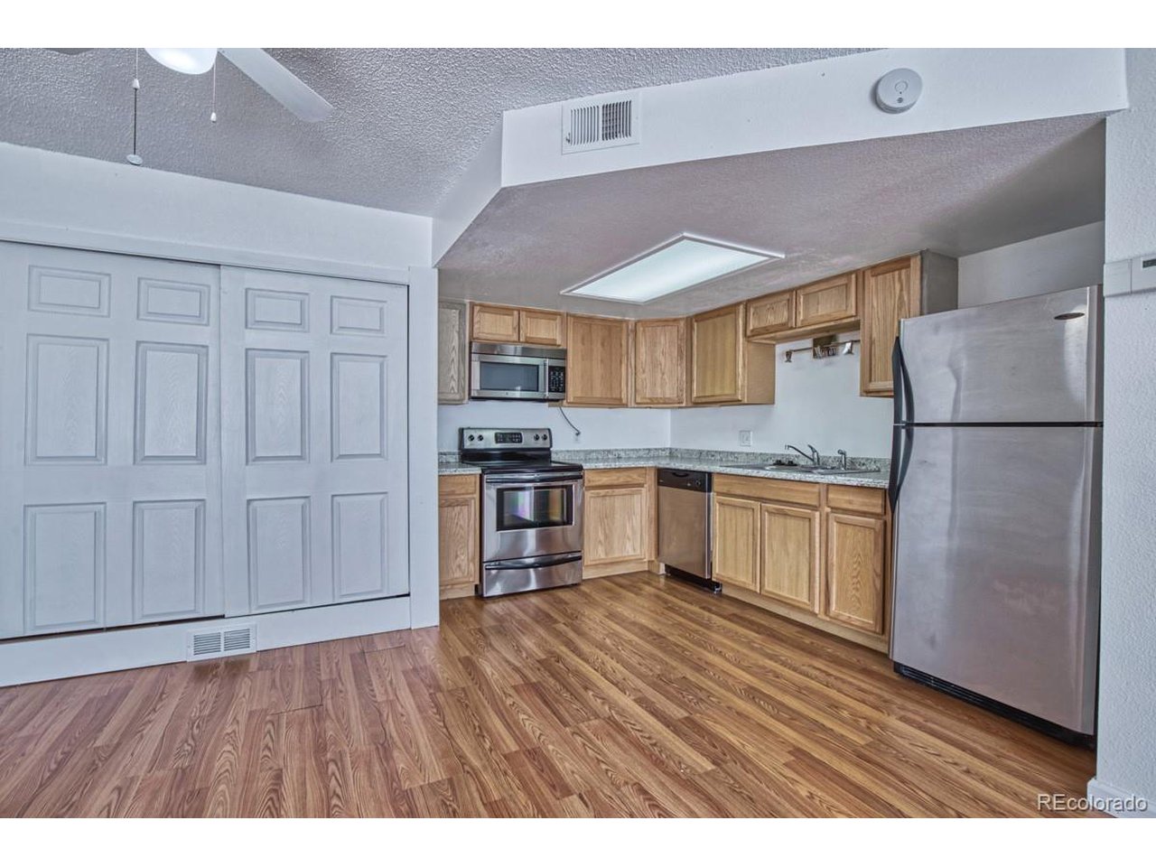 8701 Huron Street, Unit 209 Thornton, CO 80260 - Photo 7 of 25 a kitchen with a refrigerator a sink and cabinets