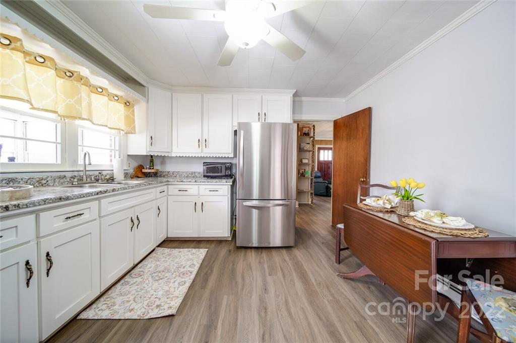 553 Loray Farm Road Dallas, NC 28034 - Photo 25 of 48 a kitchen with stainless steel appliances a stove a sink dishwasher a refrigerator white cabinets and wooden floor