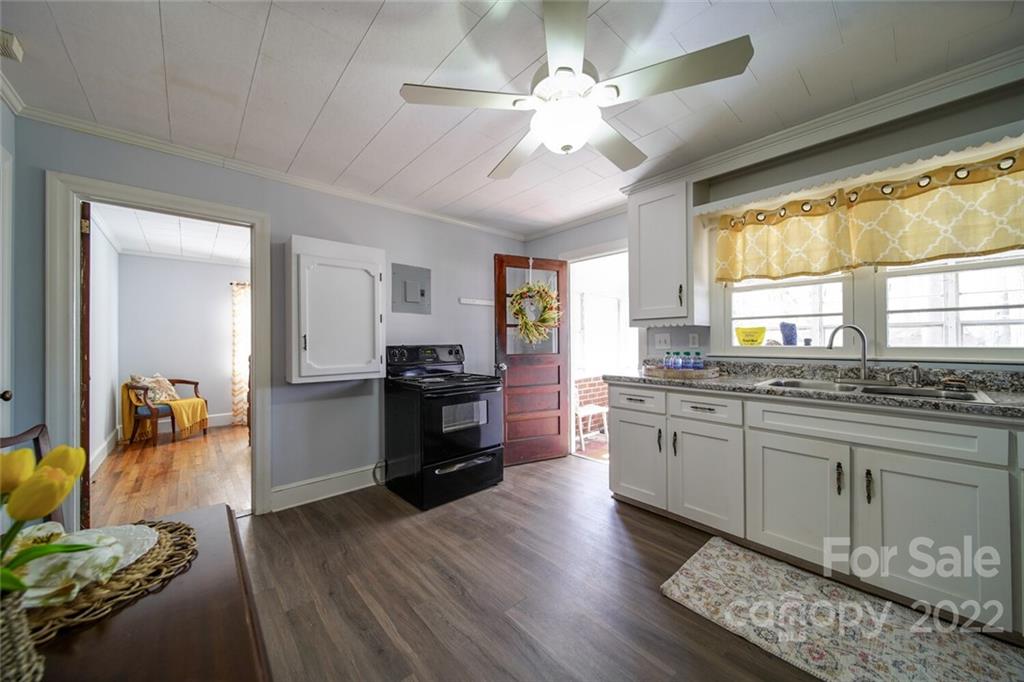 553 Loray Farm Road Dallas, NC 28034 - Photo 29 of 48 a kitchen with granite countertop a stove a sink a dining table and chairs