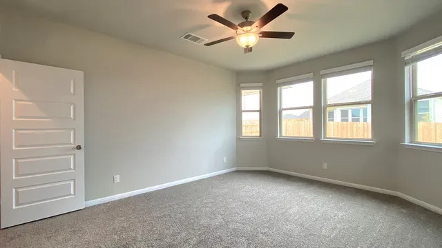 an empty room with a window and a ceiling fan