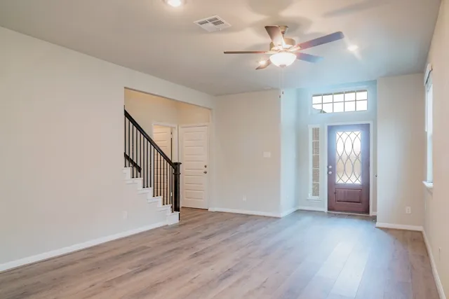 a view of an entryway with wooden floor and a ceiling fan