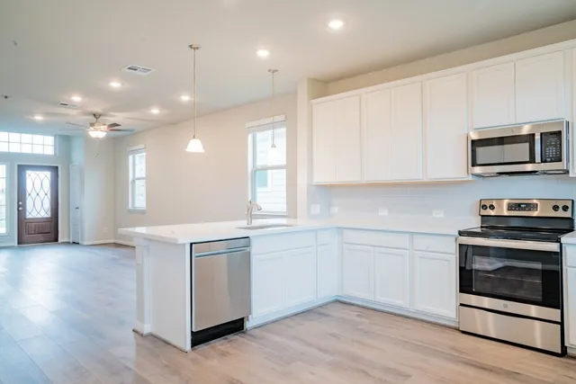 a kitchen with stainless steel appliances granite countertop a stove a sink and a microwave