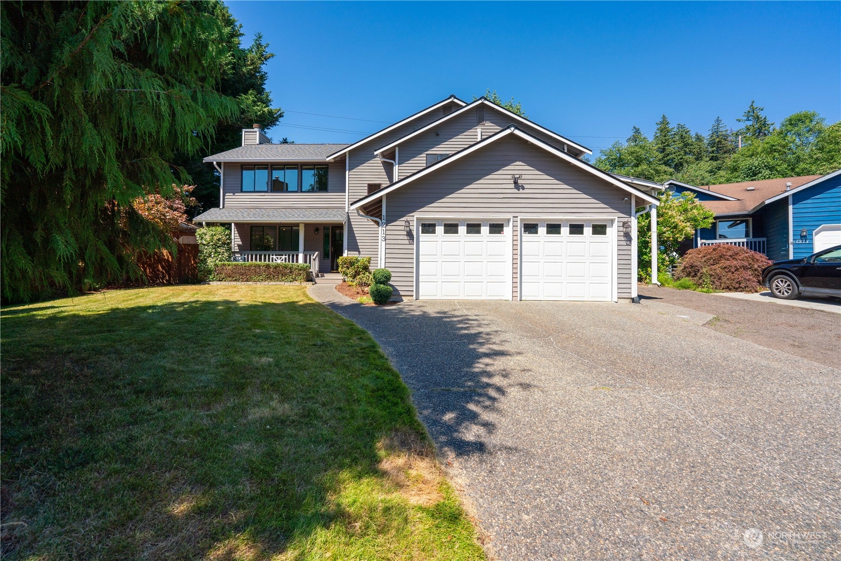 1213 228th Place Southwest Bothell, WA 98021 - Photo 1 of 40 a front view of a house with a yard and garage