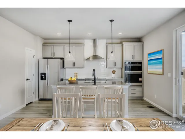 a kitchen with stainless steel appliances kitchen island granite countertop a refrigerator and a stove top oven