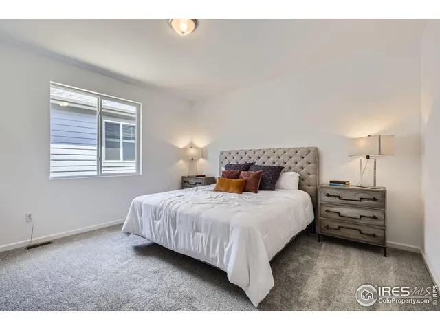 a bedroom with a bed two lamps and a window