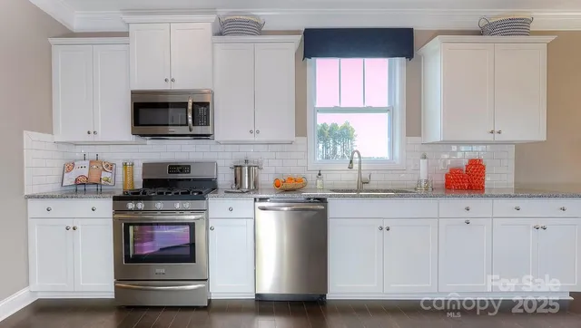 a kitchen with stainless steel appliances granite countertop a sink and a microwave