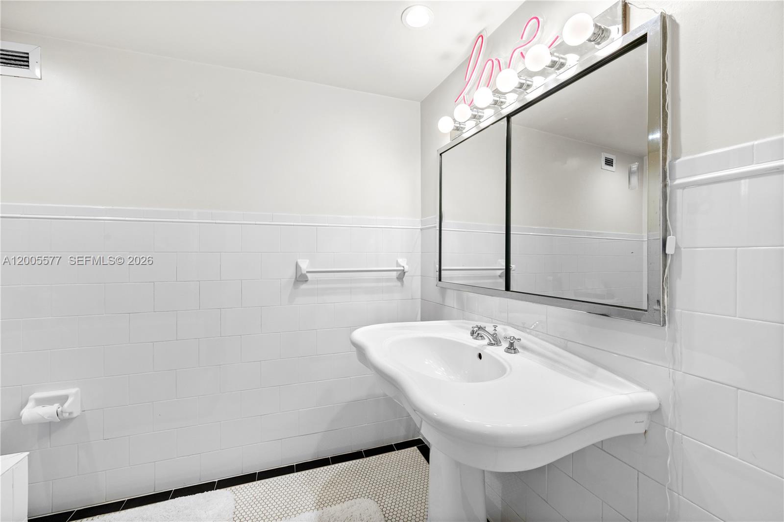 5255 Collins Avenue, Unit 11A Miami Beach, FL 33140 - Photo 7 of 15 a bathroom with a sink a mirror and a shower