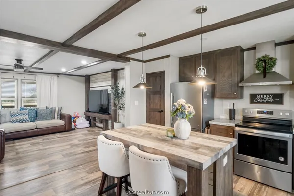 a kitchen with stainless steel appliances granite countertop a stove and a wooden floors