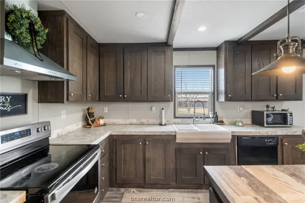 a kitchen with a sink stove top oven and cabinets