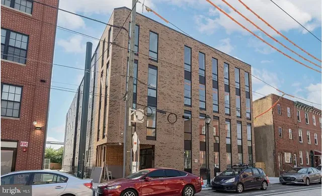 a couple of cars parked in front of brick building
