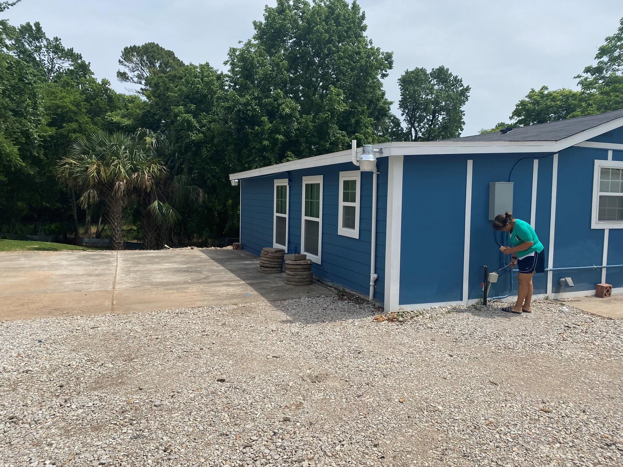 a view of backyard with potted plants and wooden fence