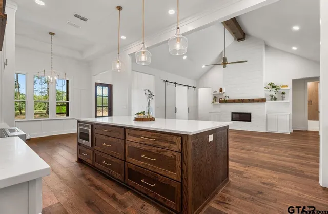 a kitchen with a stove a refrigerator and wooden floor