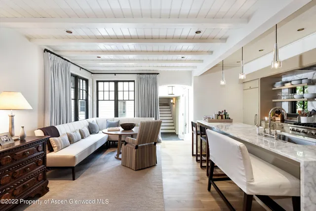a living room with furniture flat screen tv and large window
