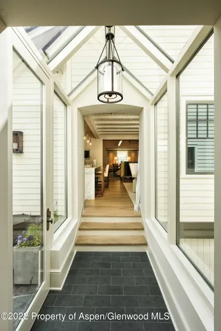 a view of a hallway with a couch and large windows