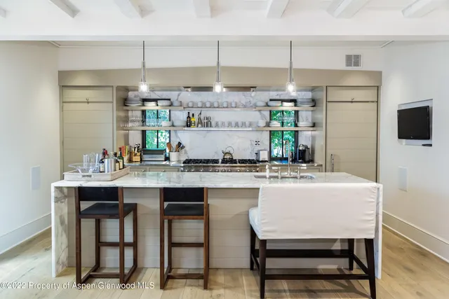 a kitchen with kitchen island a stove a table and chairs in it
