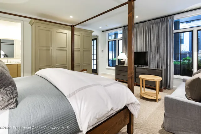 a bedroom with a bed a couch and large window