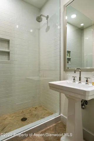 a bathroom with a shower a sink and mirror