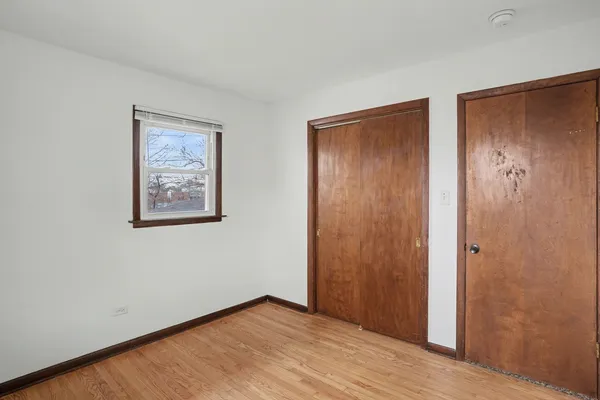 an empty room with wooden floor and closet