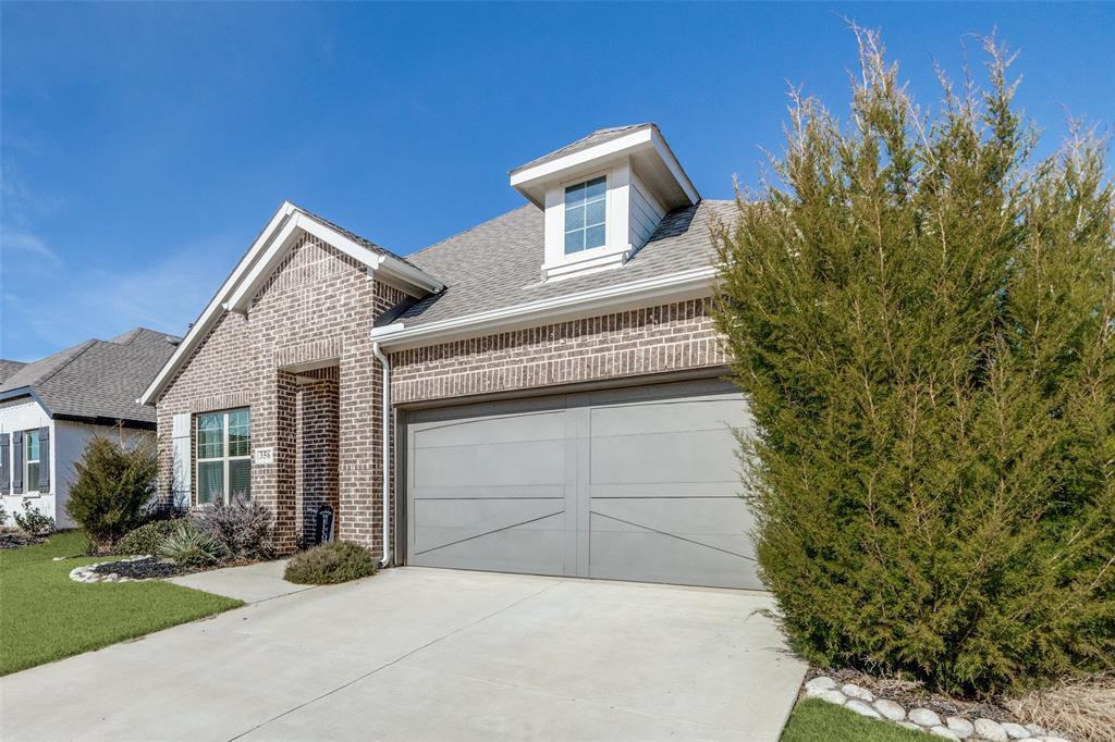 356 Greenbriar Road Little Elm, TX 75068 - Photo 2 of 25 View of front facade with a shingled roof, brick siding, driveway, and a garage