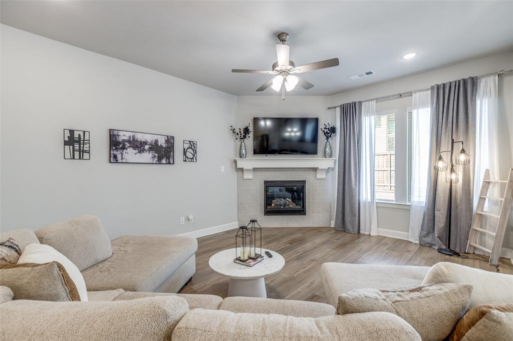 356 Greenbriar Road Little Elm, TX 75068 - Photo 7 of 25 Living room featuring wood finished floors, a tiled fireplace, ceiling fan, and recessed lighting