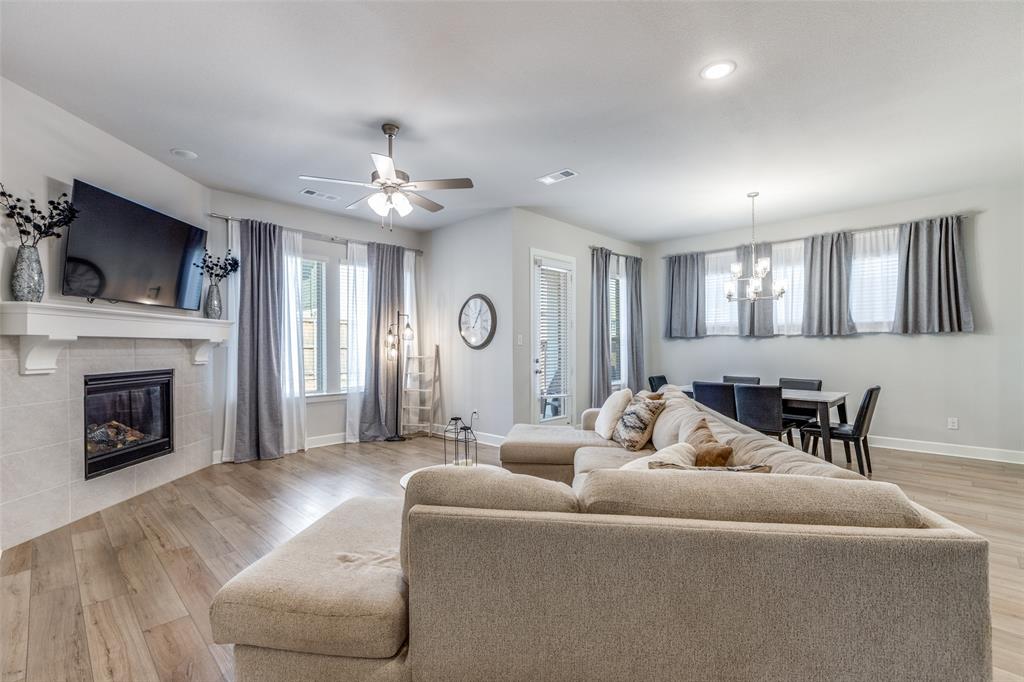 356 Greenbriar Road Little Elm, TX 75068 - Photo 8 of 25 Living room with light wood-style floors, a fireplace, ceiling fan, and suspended lighting