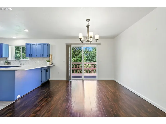 a open kitchen with cabinets wooden floor and stainless steel appliances