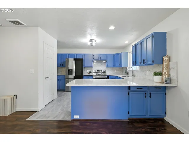 a kitchen with cabinets and wooden floor