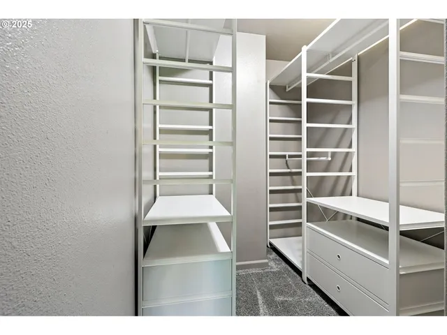 a view of walk in closet with empty racks