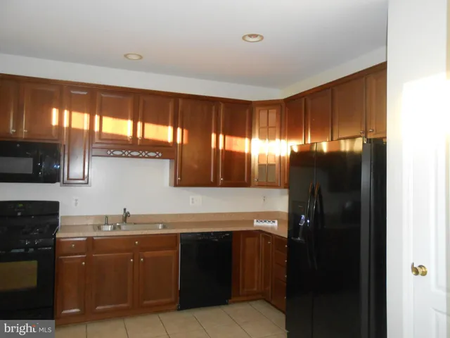 a kitchen with granite countertop a refrigerator and a sink