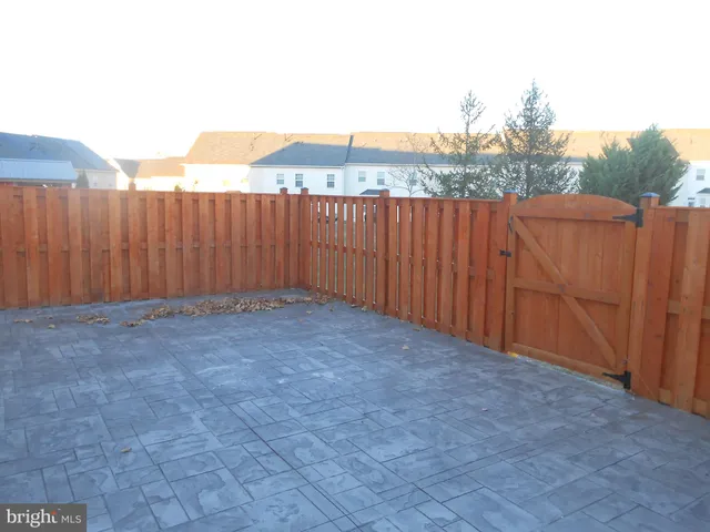 a view of backyard with wooden fence