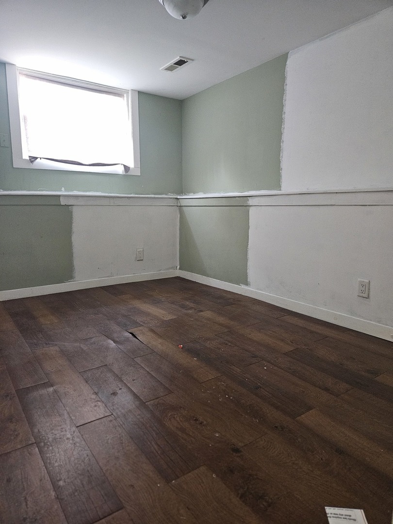 6732 South Peoria Street Chicago, IL 60621 - Photo 12 of 22 an empty room with wooden floor and windows