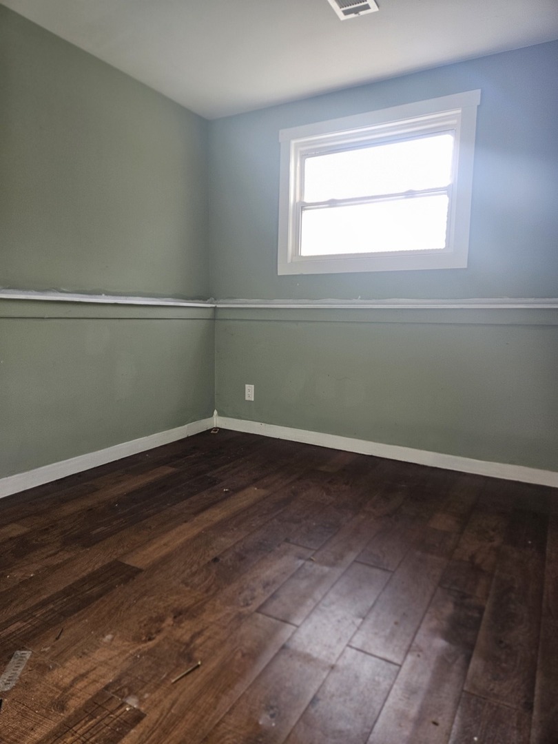 6732 South Peoria Street Chicago, IL 60621 - Photo 16 of 22 an empty room with wooden floor and windows