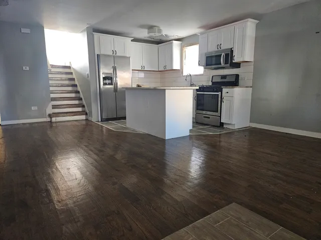 a kitchen with stainless steel appliances a stove top oven a sink and cabinets