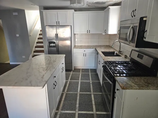 a kitchen with cabinets and steel stainless steel appliances