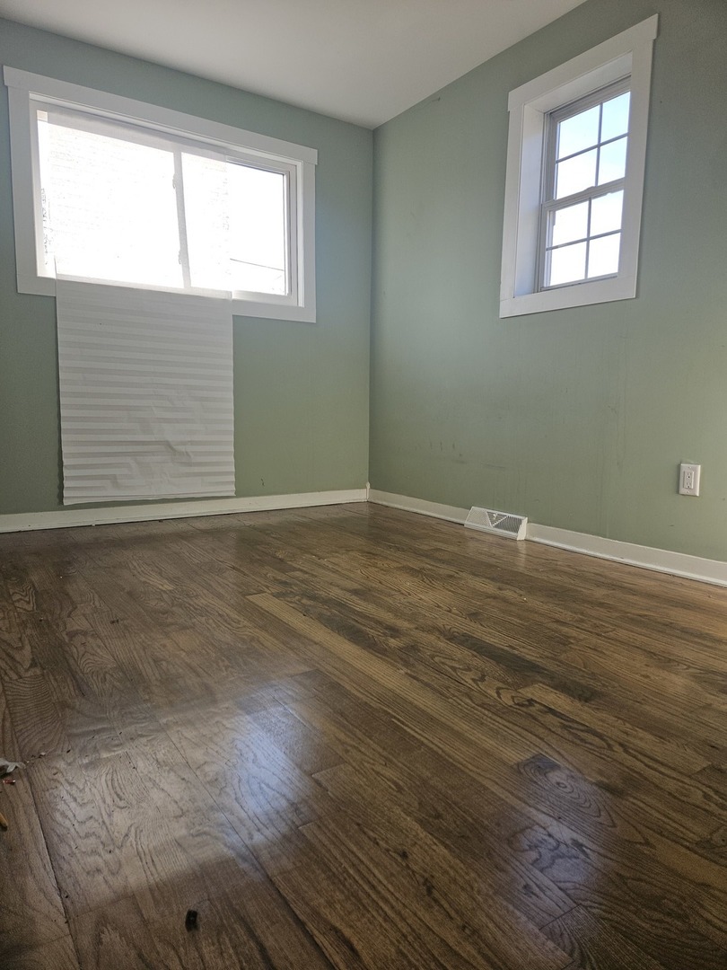 6732 South Peoria Street Chicago, IL 60621 - Photo 10 of 22 a view of an empty room with wooden floor and a window