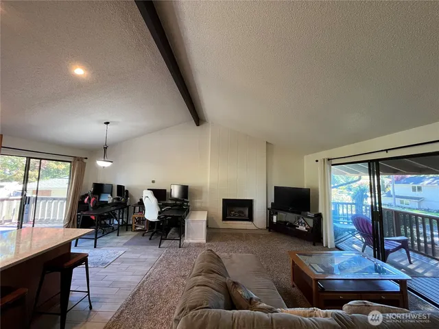 a living room with furniture fireplace and a large window