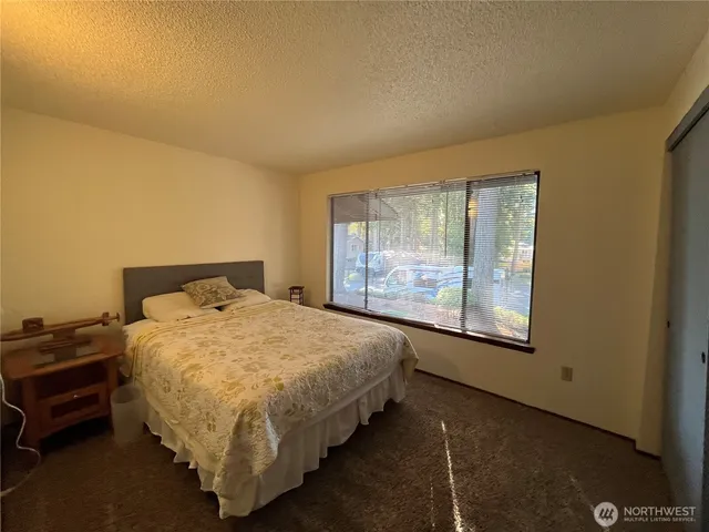 a bed sitting in a bedroom next to a window