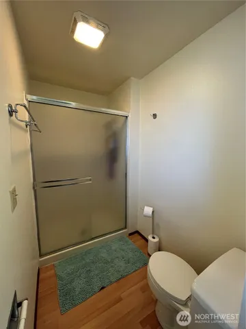 a bathroom with a granite countertop toilet and a shower