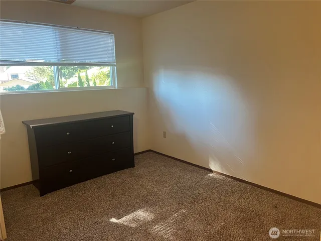 an empty room with a window and a lamp