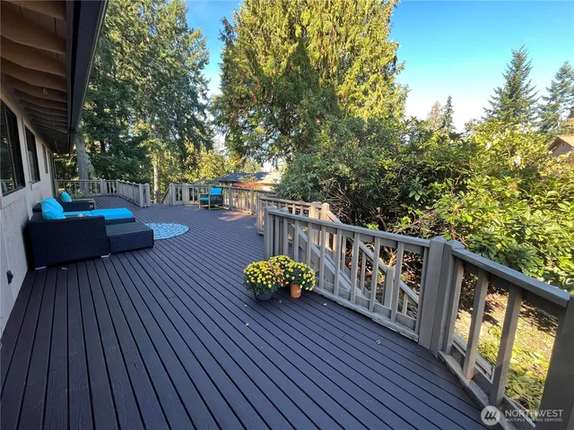a balcony with wooden floor table and chairs