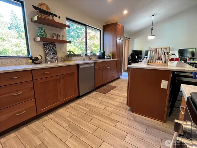 a kitchen with kitchen island granite countertop a sink cabinets and wooden floor