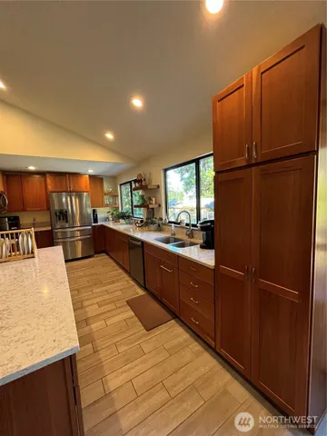a kitchen with stainless steel appliances granite countertop a refrigerator and a sink