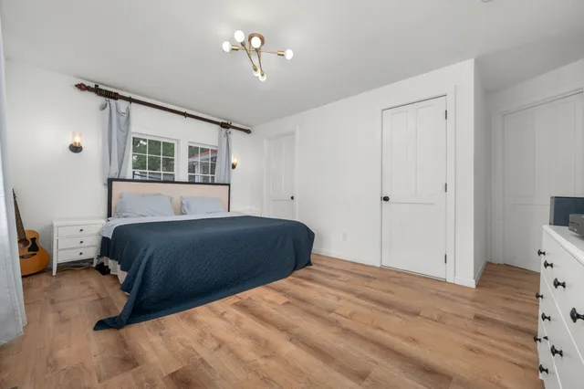a bedroom with a bed and a chandelier