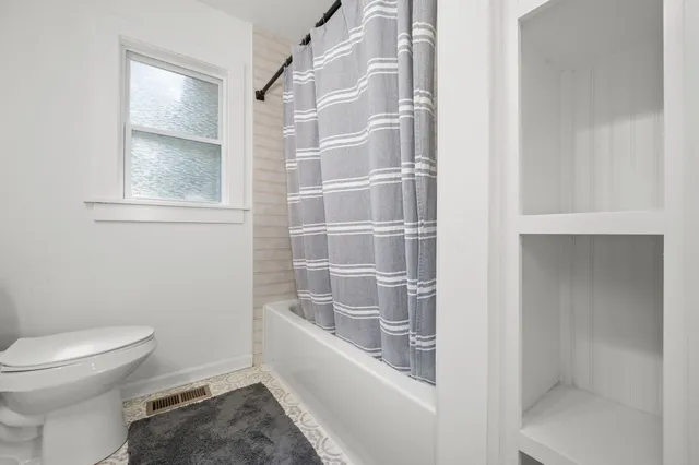 a bathroom with a toilet and a shower
