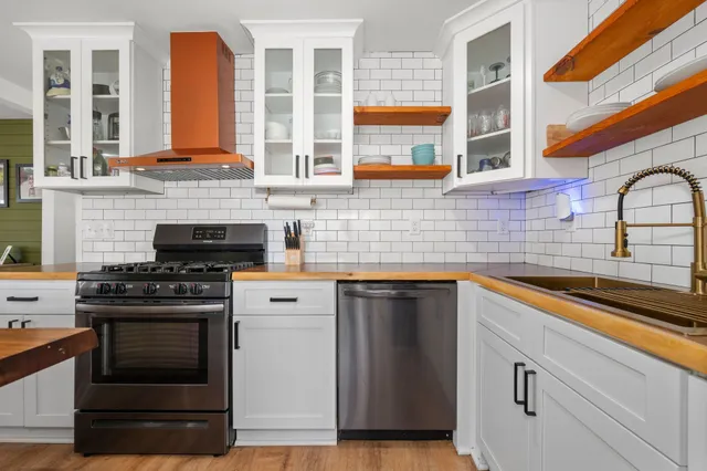 a kitchen with stainless steel appliances granite countertop a stove and a sink