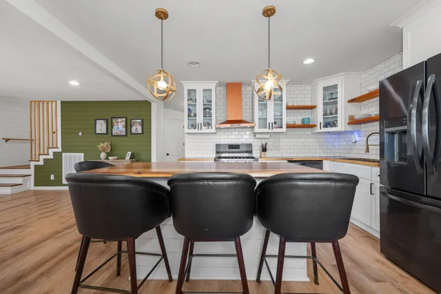 a kitchen with a table chairs refrigerator and wooden cabinets