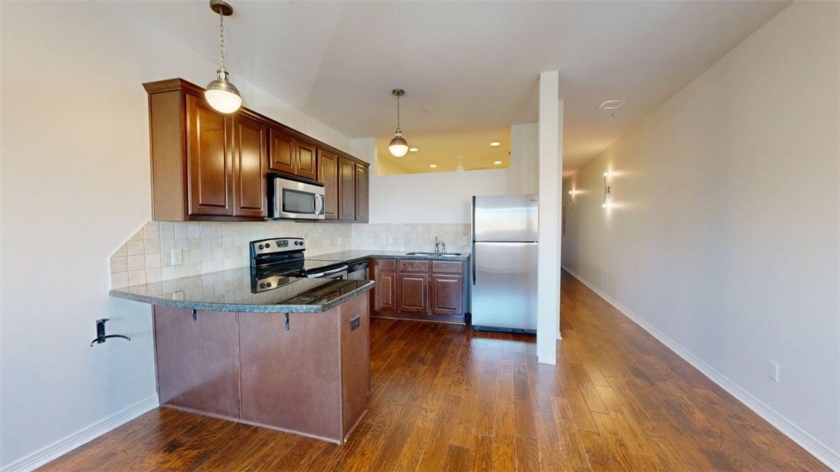 206 North Main Street, Unit 124 Bryan, TX 77803 - Photo 7 of 17 a kitchen with wooden floors and wooden cabinets