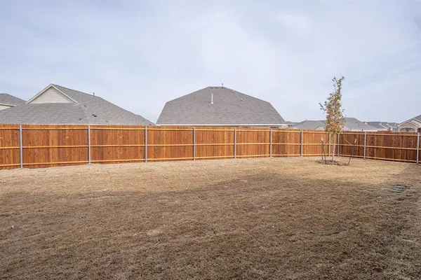 a view of a field with a big yard and wooden fence