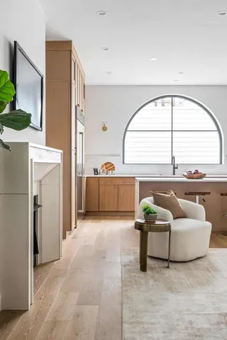 a kitchen with stainless steel appliances granite countertop a sink a stove and a dining table with wooden floor