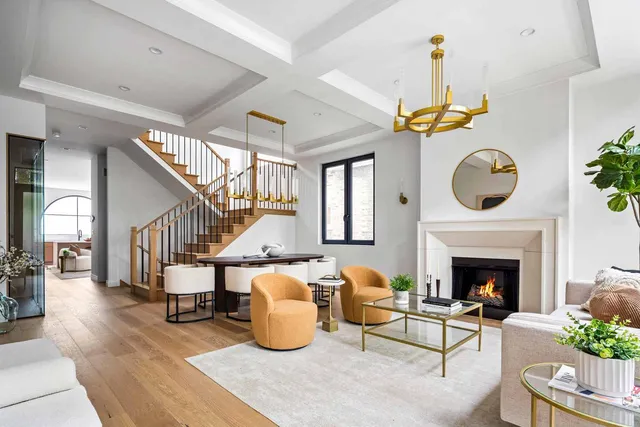 a living room with furniture a fireplace and a chandelier